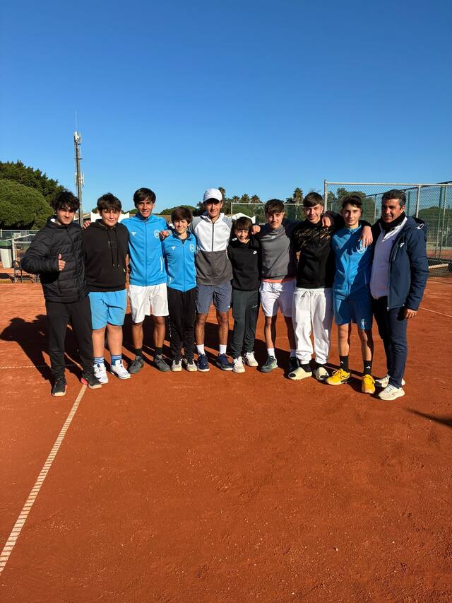 Grupo de alumnos de la escuela deportiva en las pistas de tierra batida